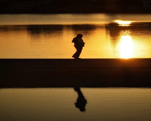 Close up of a person walking on a calm evening path reflecting balance